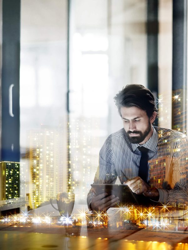 doing-business-todays-world-multiple-exposure-shot-young-businessman-working-office-superimposed-city-night (1)